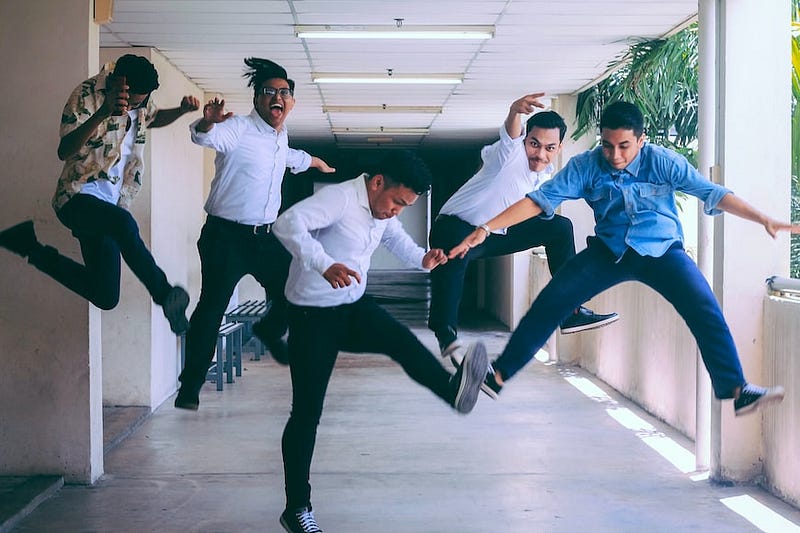 Group of employees jumping in office hallway