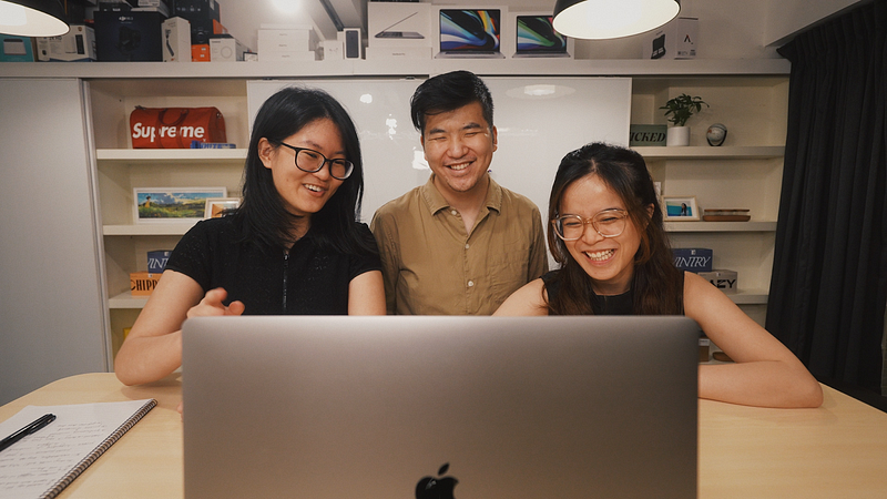 3 people looking at laptop smiling