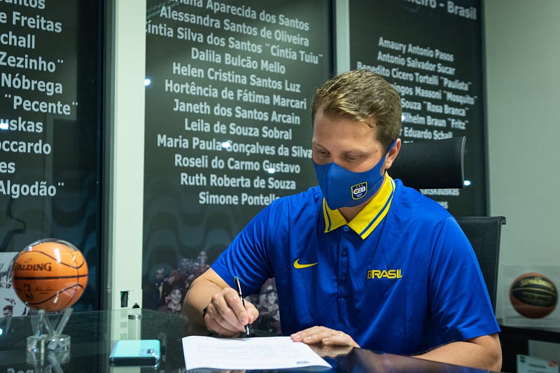 Momento da assinatura do contrato de Gustavo De Conti com a seleção
