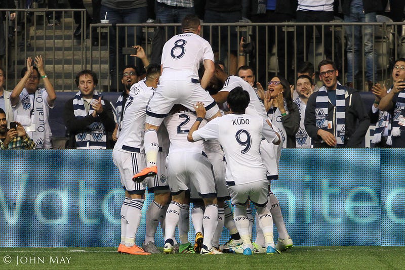 Whitecaps players celebrate the Bolanos goal.