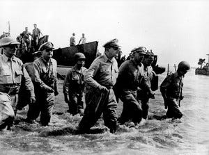 Soldiers and General Douglas MacArthur wading through water.