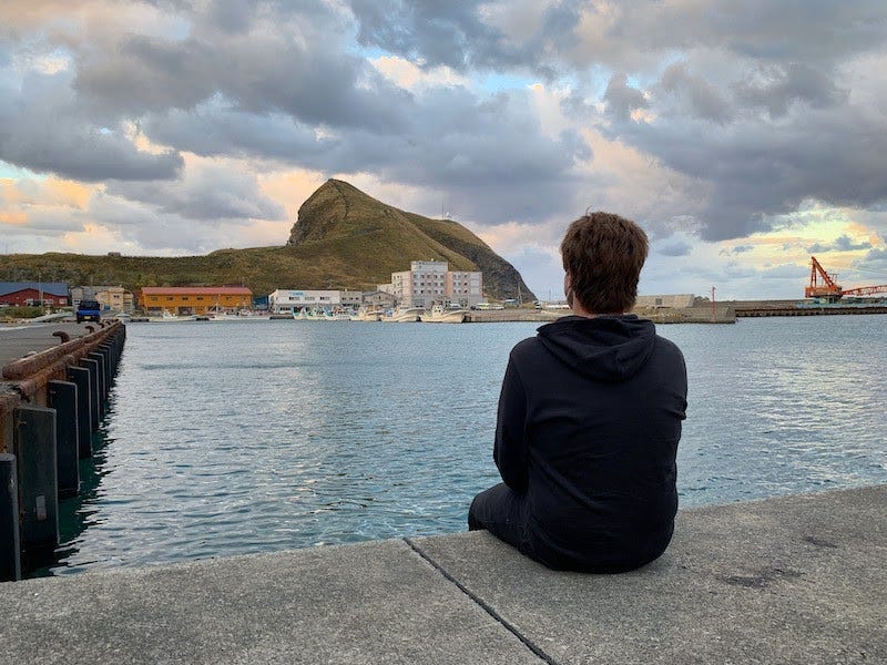 Donny Kimball sits on the side of a dock on northern Hokkaido’s Rishiri Island