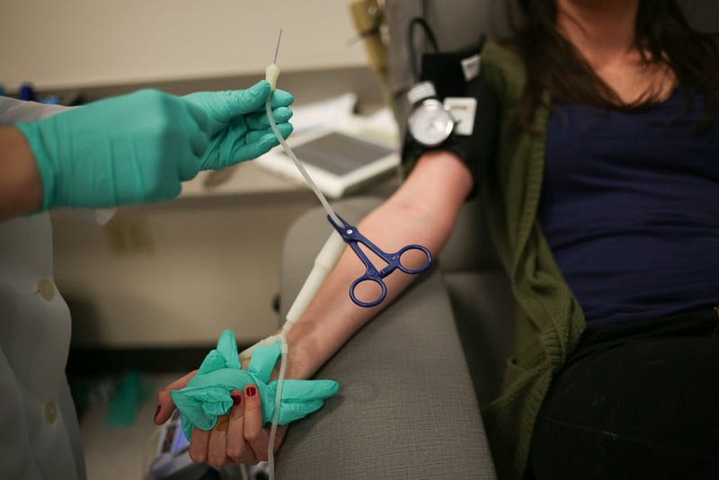 Ashley Crape, phlebotomist at Northwest Bloodworks in Bellingham, readies a needle to draw Western student Yvonne Worden's blood on June 3, 2016. 