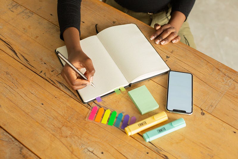 a person planning their task management using a blank notebook and a pen