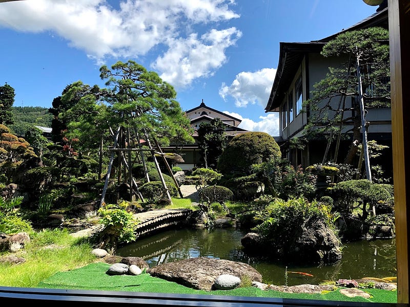 A zen garden in the middle of Dewaya Ryokan in Nishikawa complete with goldfish pond and wooden slat bridge.