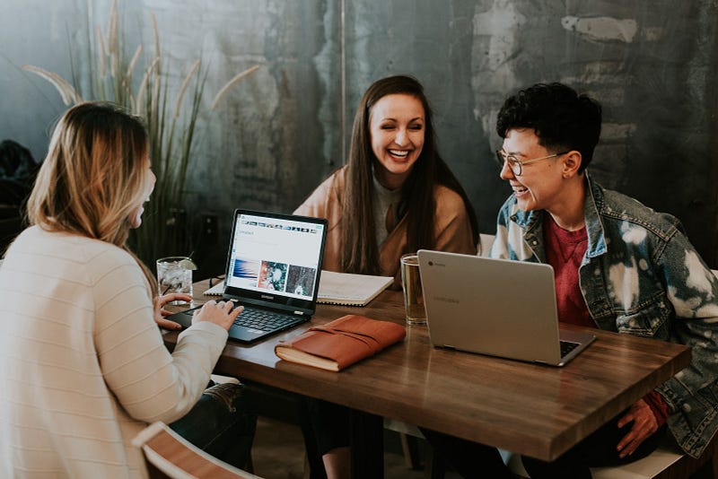 Three young woman laughing while working