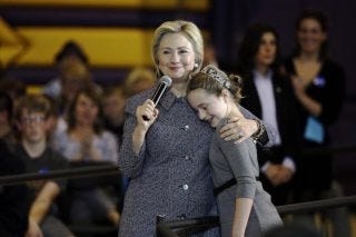 Democratic presidential candidate Hillary Clinton gets a hug from fifth-grader Hannah Tandy during a town hall meeting at Keota High School, Tuesday, Dec. 22, 2015, in Keota, Iowa. (AP Photo/Charlie Neibergall)