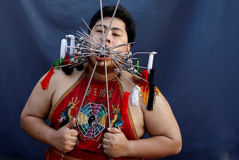 A devotee of the Chinese Samkong Shrine with spikes pierced through his cheeks takes part in a procession celebrating the annual vegetarian festival in Phuket, Thailand, October 4, 2016 . REUTERS/Jorge Silva