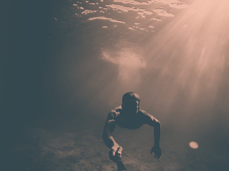 Un uomo sott'acqua con un raggio di luce che proviene dall'esterno