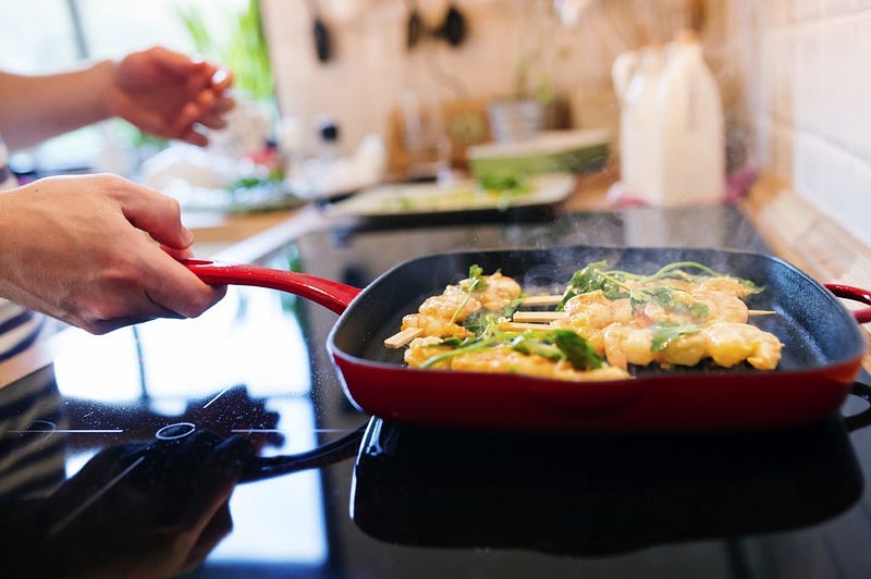 Man in the kitchen preparing king prawns