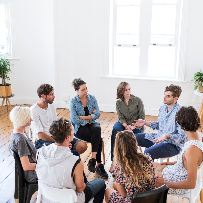 A man talking in group therapy session.