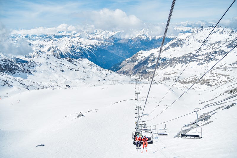 Cable car in the alps in wintertime. Skiiers moving up.