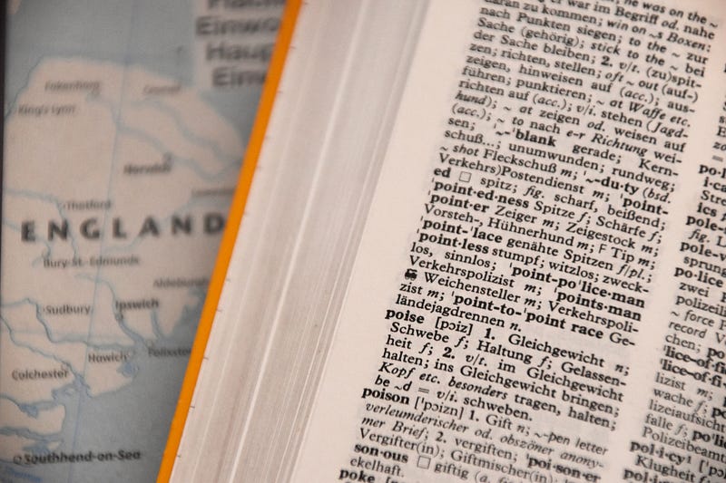 A dictionary, open and lying atop a map of England