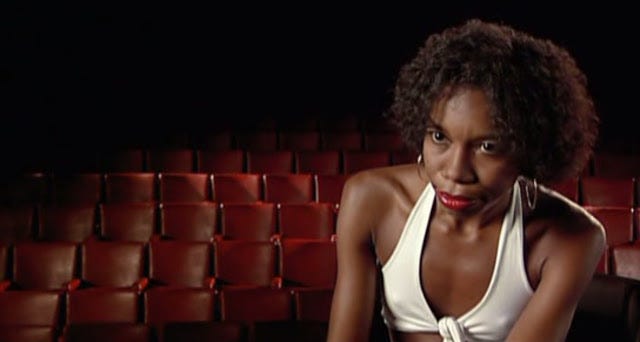 A black actress in a theatre in the documentary Jogo De Escena