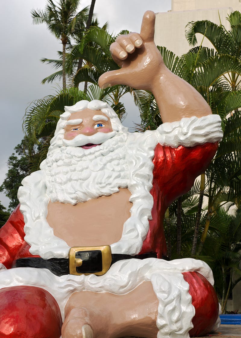 Hawaiin Shaka Santa with white beard and red dress with hang loose gesture.