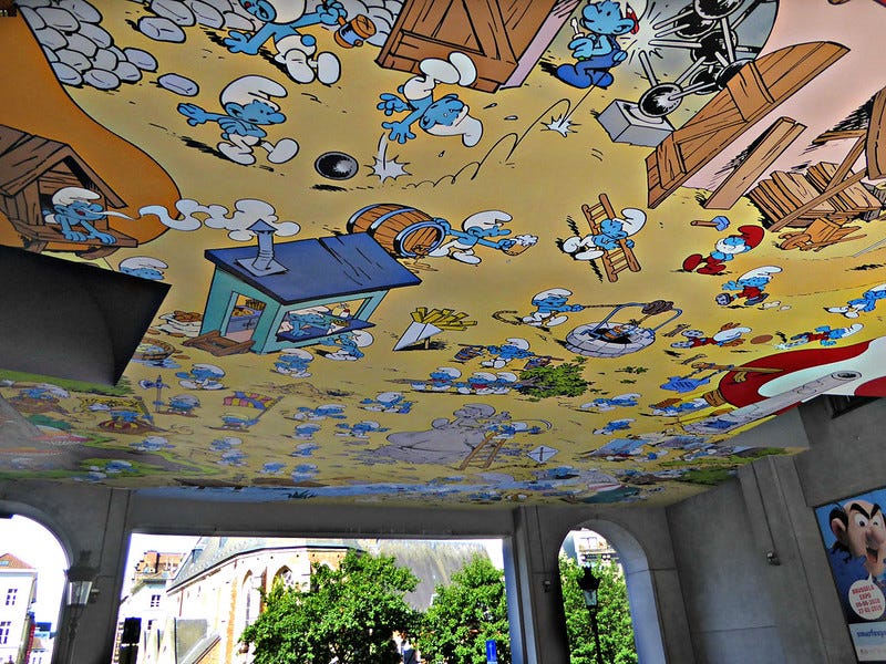 An expansive ceiling mural of scenes from the Smurfs cartoon.