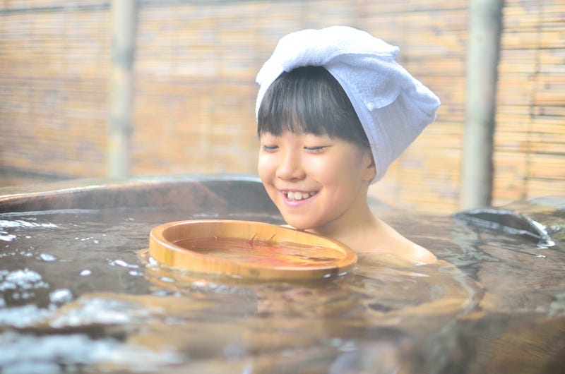 A girl soaks in an onsen at a ryokan in Japan