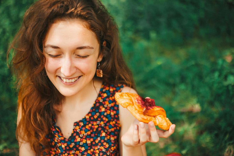 A woman eating pastry.