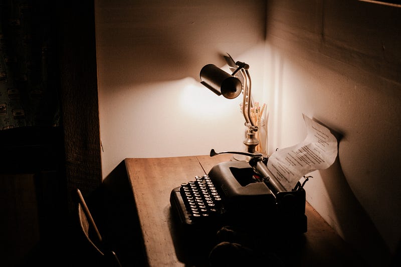 Old school journalism typewriter on wooden desk.