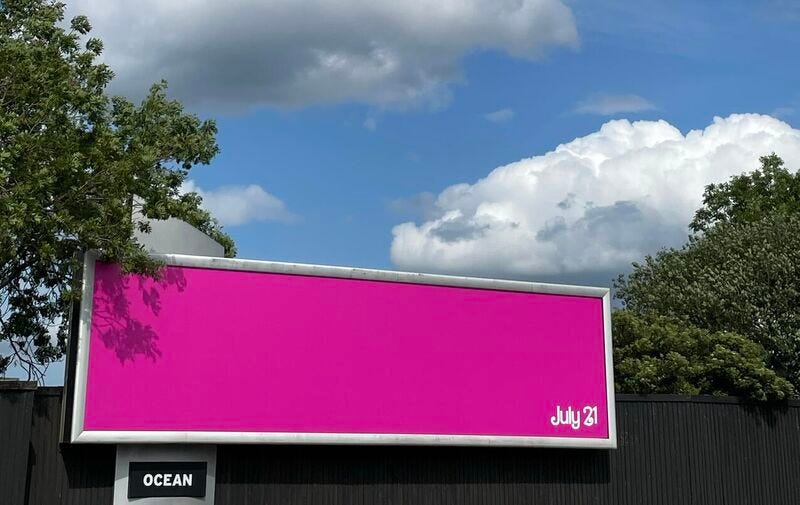 Billboard in Glasgow with only a pink background, and stylized July 21 text.