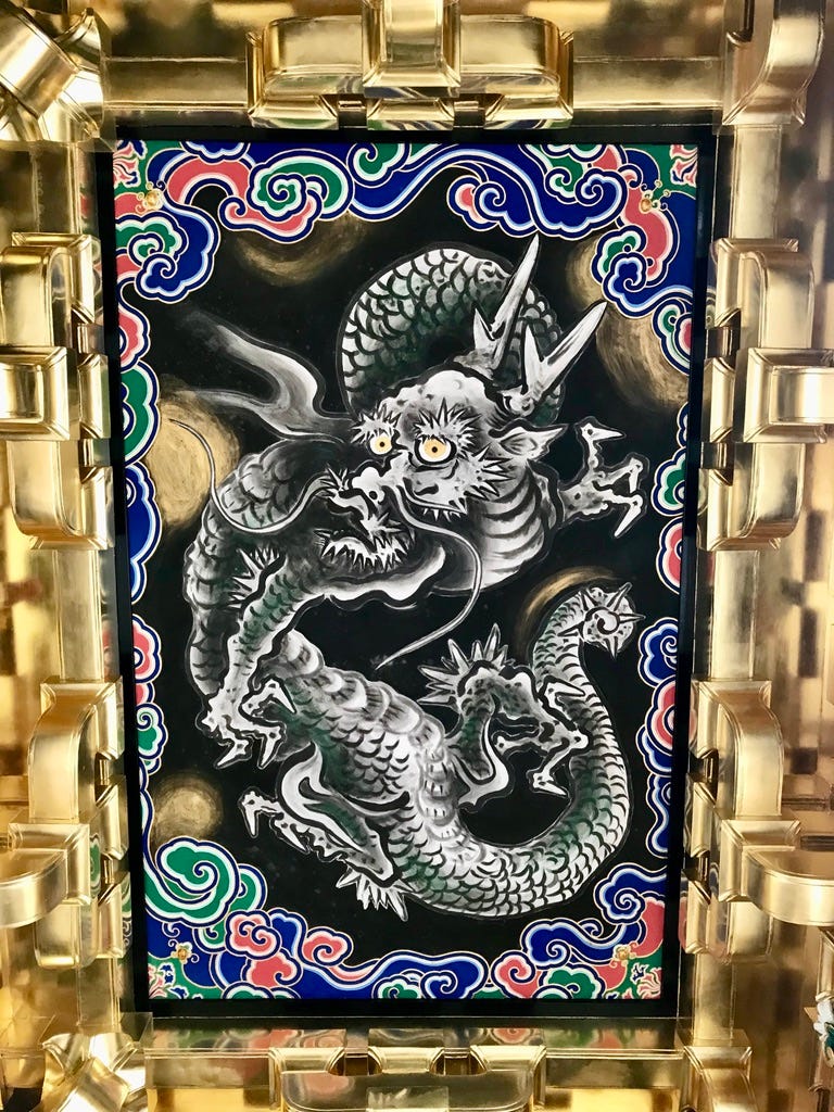 Dragon painting surrounded by gold-leaf covered wood.