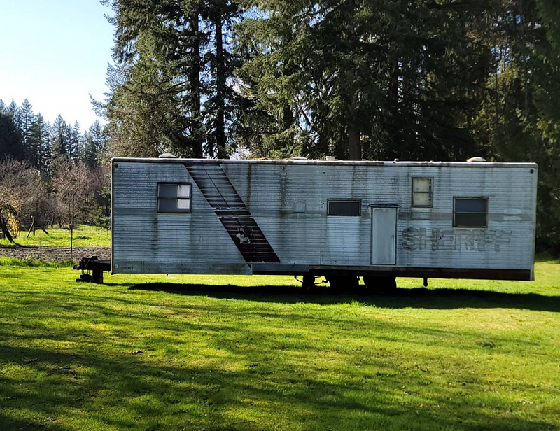 A very moldy metal trailer with the words “Sheriff” painted on the side.