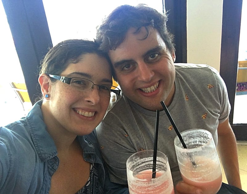 My husband and I at the bar with our drinks, pizza shirt, drinks, pina colada with some strawberry flavor