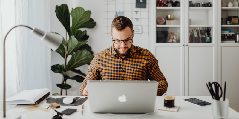 Man in glasses working at a laptop — How I Make $5,000 Each Month With Quiet Over-Employment