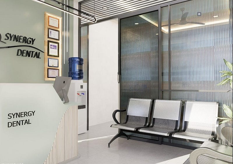 This modern dental clinic interior design features a well-planned waiting area with ergonomic metal seating and frosted glass cabin partitions for privacy and openness. The soft green reception backdrop, minimalist reception counter, and warm ceiling lighting create a calm, hygienic, and welcoming environment.