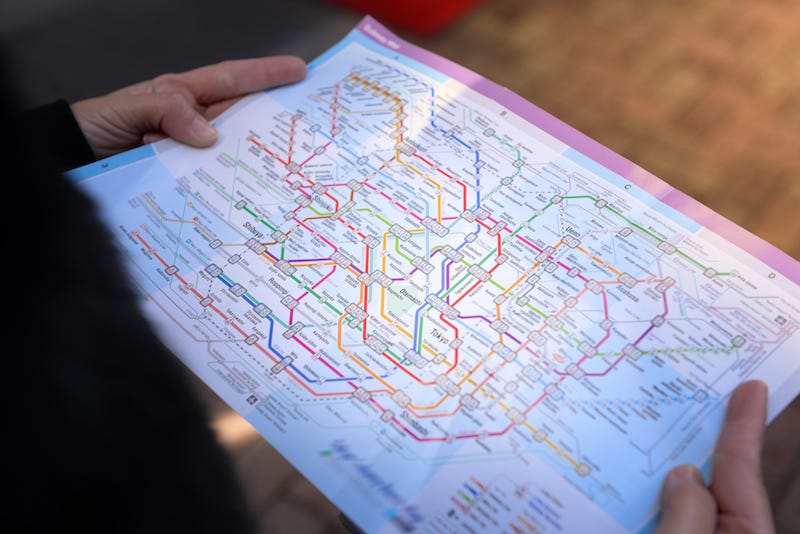 A tourists looking to make the most out of his JR Rail Pass tries to decipher a map of Tokyo’s trains
