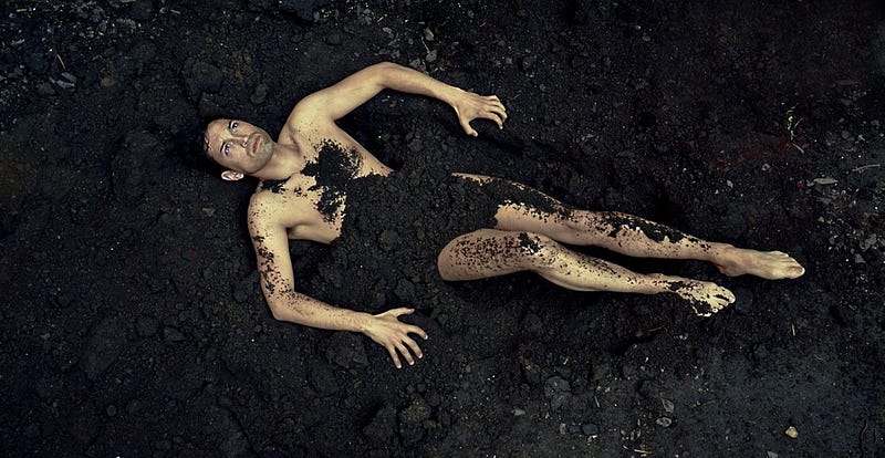 Man laying in dirt April showers day