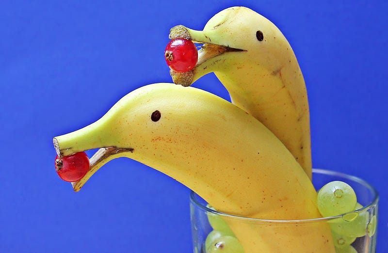 Two bananas in a glass.