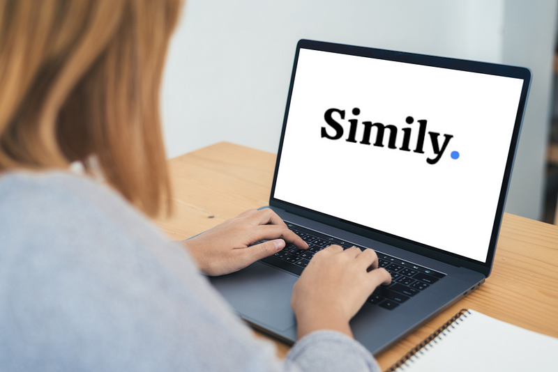 Woman types Simily in front of laptop