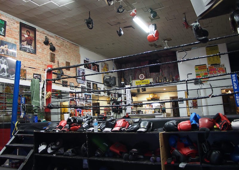 Boxing gloves and ring inside a gym