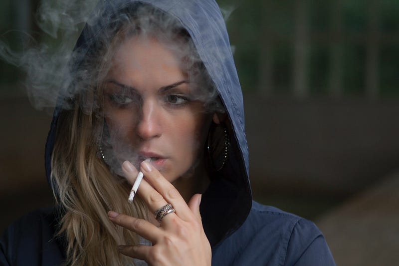Woman in hoodie smoking