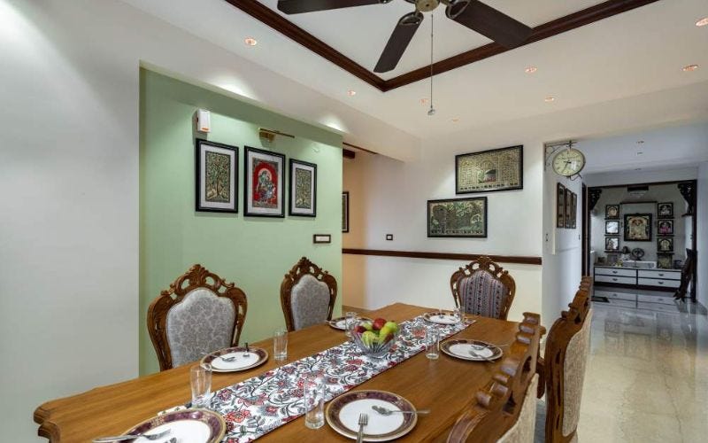 A tastefully designed dining room with a table and a ceiling fan, showcasing elegant home interior design.