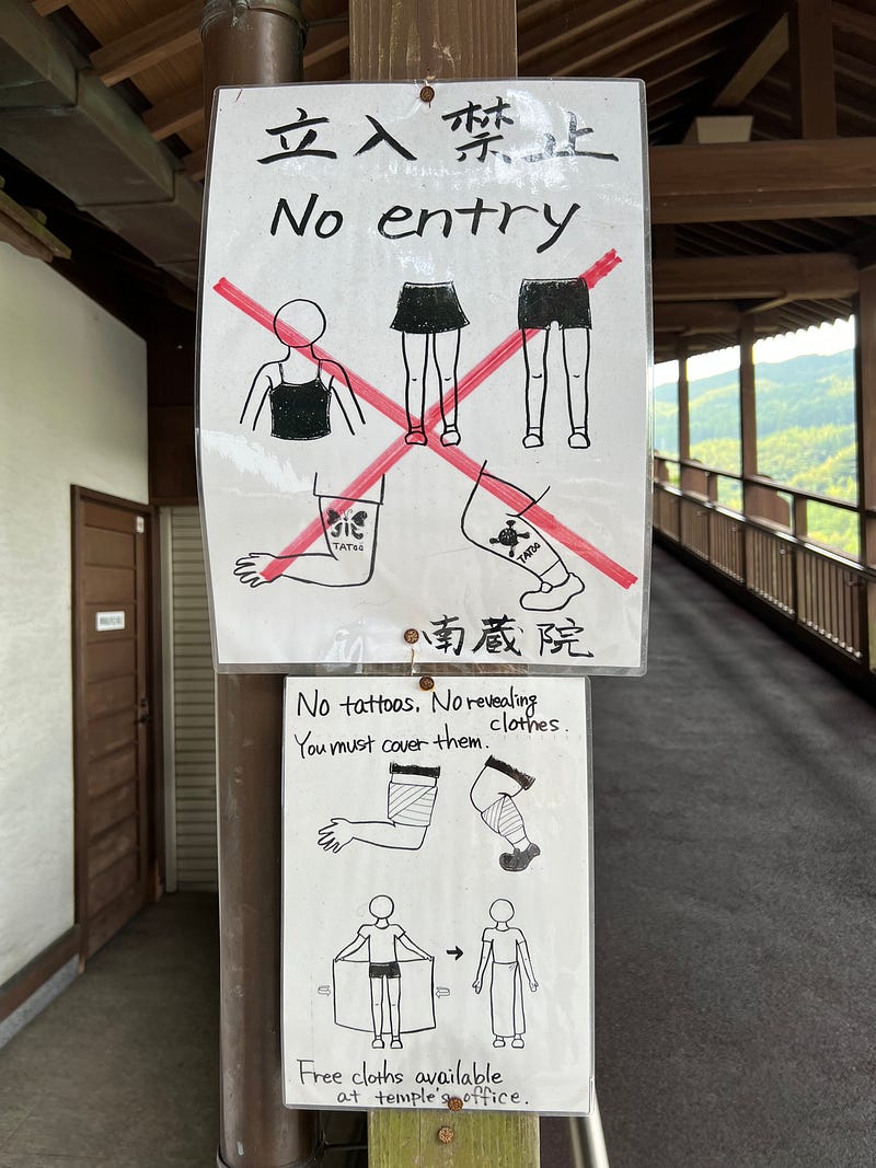 Hand drawn sign warning visitors against wearing revealing clothing or showing tattoos.