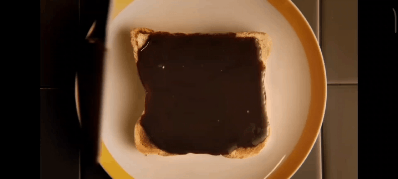 A GIF of a large amount of Marmite being spread on toast