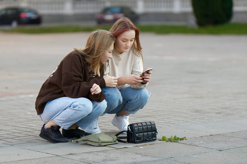 Two women sitting in deep squat.