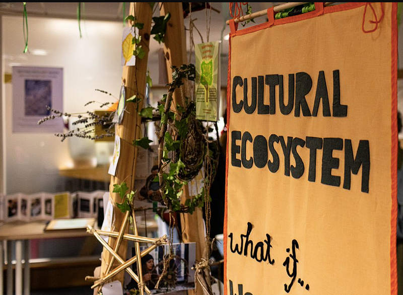 Photo from Cultural Collaborators December Gathering. Showing an organge canvas banner with the writing cultural ecosystem —