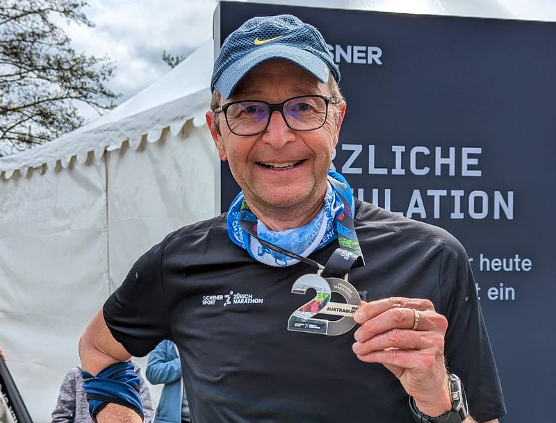 Author holding a 20th anniversary Zurich Marathon medal