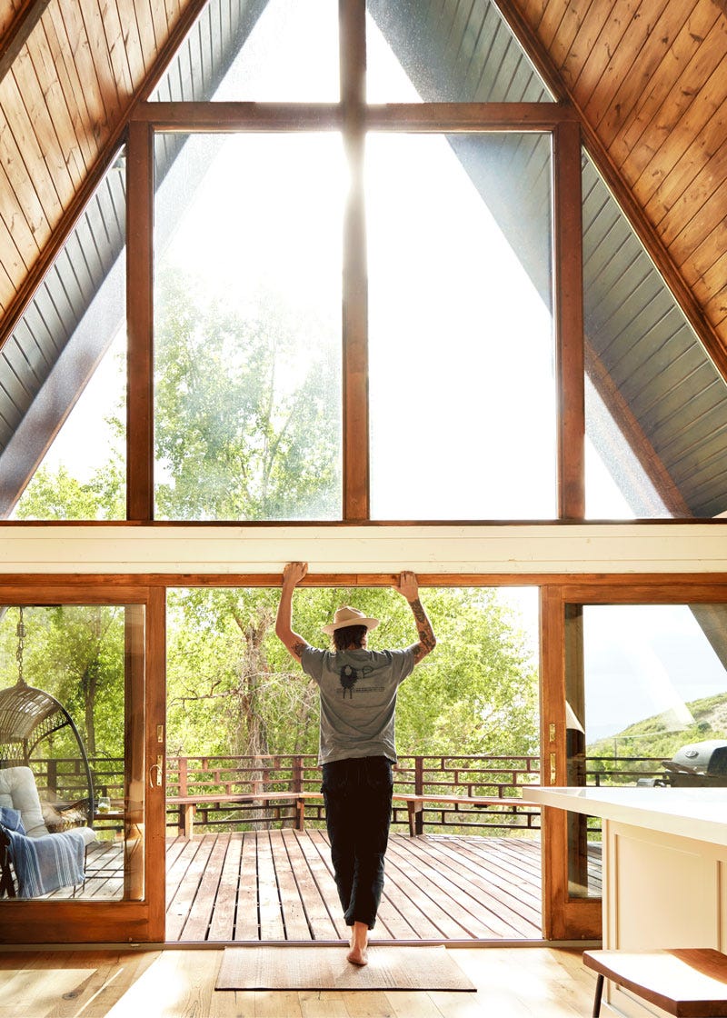 A person leans on the frame of an A-frame house in Heber, Utah.