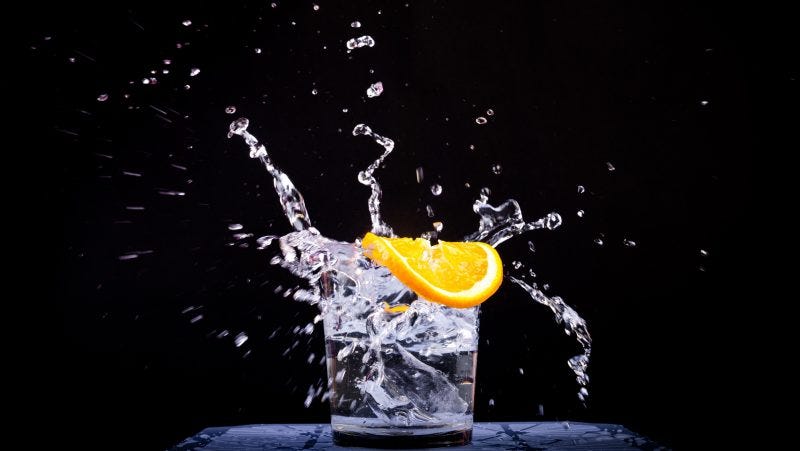 A glass of water placed across a black background