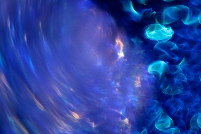 Abstract blue photograph, looks like moving water or liquid with reflections of light, taken for healing by a medical doctor