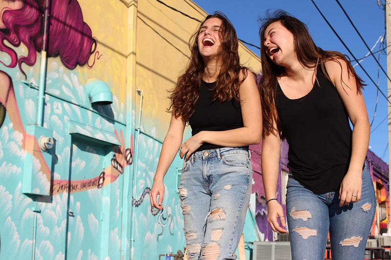 Two woman walking and laughing.