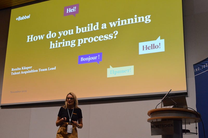 Woman giving presentation about "How do you build a winning hiring process?"