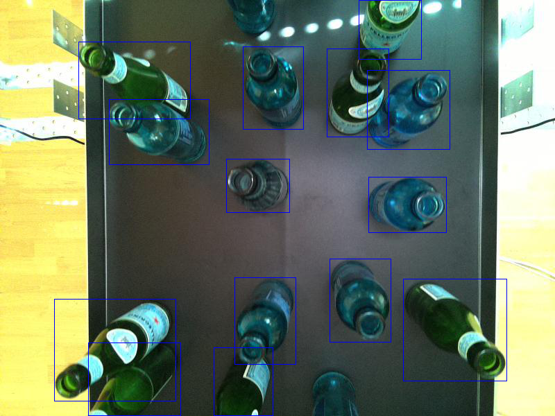 Image showing bottles standing on a conveyor belt. The bottles are labeled with bounding boxes assigned by our fine-tuned YOLOv7.