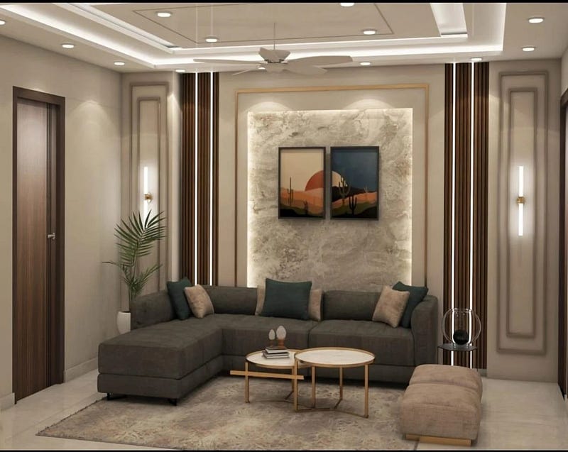 This modern living room interior design reflects a perfect balance of elegance and comfort. Featuring a stylish L-shaped sofa, warm wooden wall panels, marble-textured accent wall, and soft ambient lighting, the space feels both luxurious and inviting. Thoughtfully designed false ceiling lights enhance the depth and symmetry, making this living room ideal for contemporary homes seeking modern interior aesthetics.