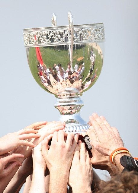 Cup being held up in victory.