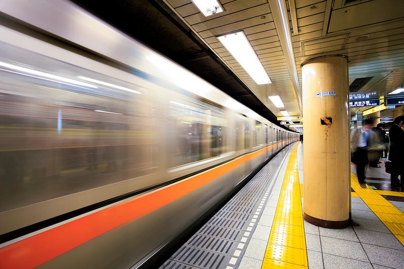 A passengers on a train zip through central Tokyo en route to a Toro Nagashi celebration